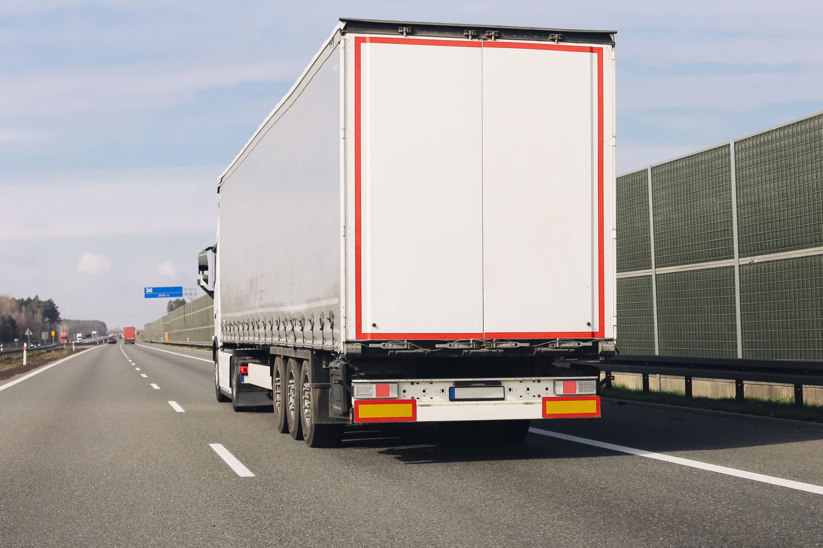 White cargo truck driving on a highway